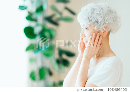 一位老年女性覺得自己的皮膚被滋潤了。 一位老年女性覺得自己的皮膚被滋潤了。 108486403