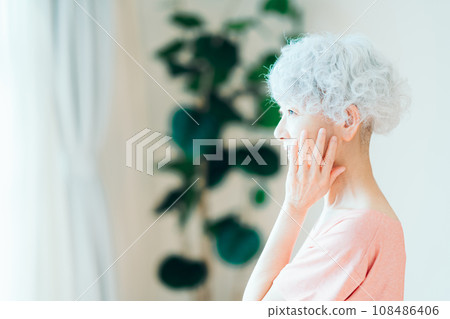 A senior woman feels that her skin is moisturized. A senior woman feels that her skin is moisturized. 108486406
