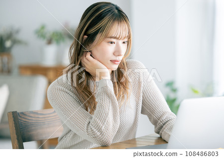 Women's lifestyle: A woman operating a computer at home Women's lifestyle: A woman operating a computer at home 108486803