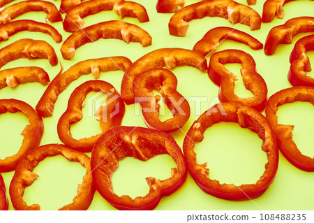 Red sweet ripe pepper cut into circles,slices on green Red sweet ripe pepper cut into circles,slices on green 108488235