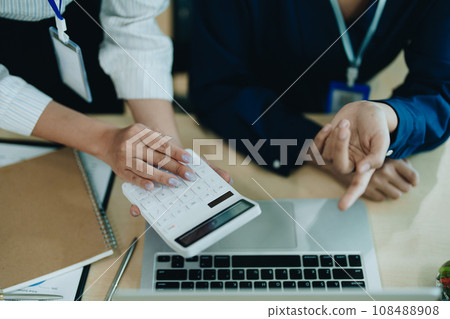 Two business people meeting to talking or discuss marketing work in workplace using paperwork, calculator, computer to work. 108488908