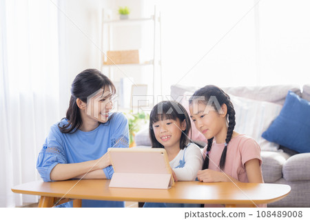 Family: Mom and girl watching videos on tablet Family: Mom and girl watching videos on tablet 108489008