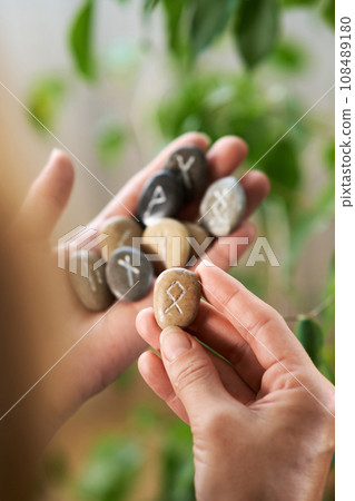 stone runes in a woman's hand stone runes in a woman's hand 108489180
