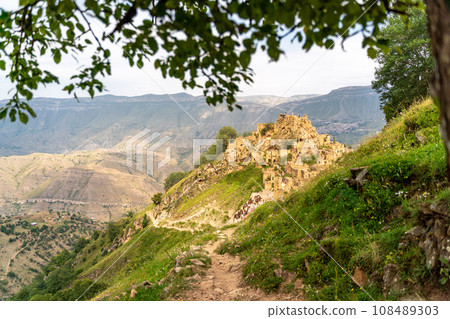 Dagestan Gamsutl. Ancient ghost town of Gamsutl old stone houses in abandoned Gamsutl mountain village in Dagestan, Abandoned etnic aul, summer landscape. Dagestan Gamsutl. Ancient ghost town of Gamsutl old stone houses in abandoned Gamsutl mountain village in Dagestan, Abandoned etnic aul, summer landscape. 108489303
