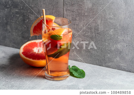 Iced tea with mint and grapefruit on a grey background. Iced tea with mint and grapefruit on a grey background. 108489858