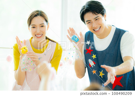 Nursery teacher making teruteru bozu at nursery school 108490209