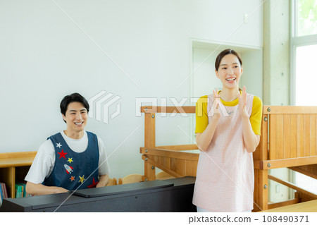 Nursery teacher playing the electronic piano 108490371