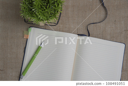 An open notebook with a pencil placed , symbolizing creativity and ideas in a cozy home setting. 108491051