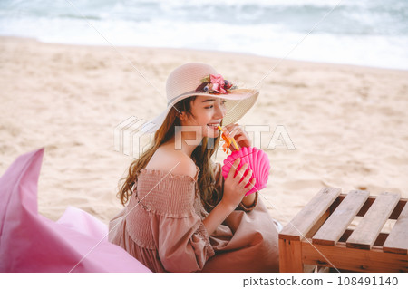 Woman with cocktail in cafe on beach 108491140