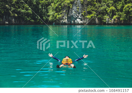 Happy traveler asian man with life jacket relax travel on sea in Maya Bay Phuket Thailand Happy traveler asian man with life jacket relax travel on sea in Maya Bay Phuket Thailand 108491157