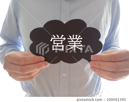 一名男子拿著一張寫有「銷售」的卡片 一名男子拿著一張寫有「銷售」的卡片 108491395