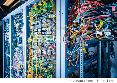 Server rack with fiber optic cables attached to front panel switch ports 108491570