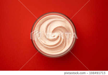 Bowl of strawberry yogurt on red background, top view Bowl of strawberry yogurt on red background, top view 108491713