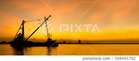 Industry landscape on sunset Engineering shipping crane depot at logistic export terminal control. Silhouette Warehouse freight background container yard loading quayside harbor port with copyspace 108491782