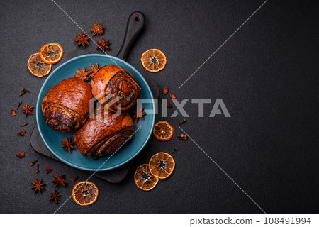 Delicious fresh sweet baked buns with poppy seeds and cinnamon on a ceramic plate Delicious fresh sweet baked buns with poppy seeds and cinnamon on a ceramic plate 108491994