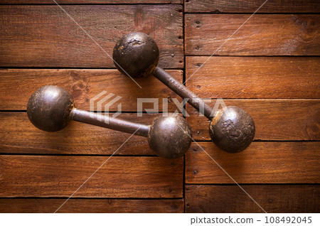Old rusty dumbbells on wood background texture 108492045