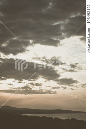 Abstract background sky Dawn Sunset Contrast dark shadow bright cloud sun orange silhouette above the mountains near the sea 108492192