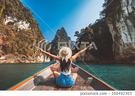 Traveler asian woman relax and travel on Thai longtail boat in Ratchaprapha Dam at Khao Sok National Park Surat Thani Thailand 108492303