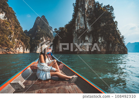 Traveler asian woman relax and travel on Thai longtail boat in Ratchaprapha Dam at Khao Sok National Park Surat Thani Thailand 108492310