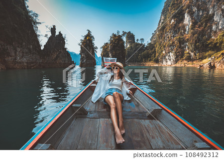 Traveler asian woman relax and travel on Thai longtail boat in Ratchaprapha Dam at Khao Sok National Park Surat Thani Thailand 108492312