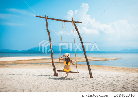Traveler asian woman relax and travel in swing on summer beach at Koh Rap Samui in Surat Thani Thailand 108492316