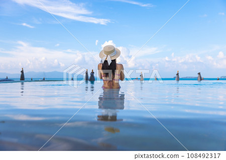 Asian travel bikini woman relax in infinity pool resort at Koh Samui beach Thailand 108492317
