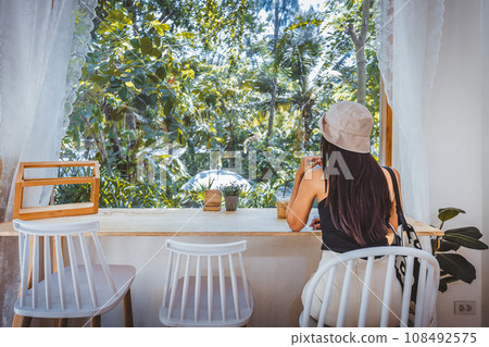 Traveler asian woman with Ice coffee plastic cup relax in cafe at Thailand 108492575