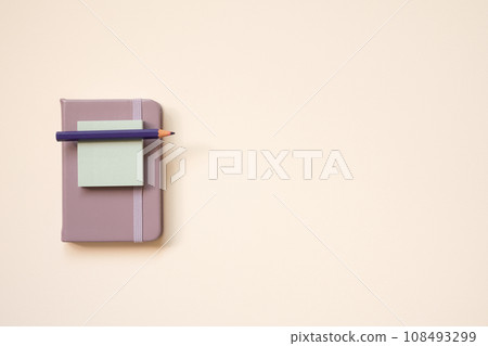 Light purple diary notebook and notepad, colored pencil on pink desk background. top view, copy space 108493299