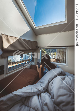 Travel woman with mobile phone relax inside a camper car recreational vehicle 108493361