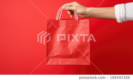 Close up female holds in hand white clear empty blank craft paper gift bag for purchases after shopping isolated on red background. Packaging template mockup. Delivery concept advertising mock 108493388