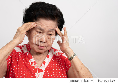 A senior woman who has a severe headache suffers from a stroke ,brain disease,patient holding head with her hand,suffering from senile dementia,memory disorders, confused old elderly with Alzheimer A senior woman who has a severe headache suffers from a stroke ,brain disease,patient holding head with her hand,suffering from senile dementia,memory disorders, confused old elderly with Alzheimer 108494136