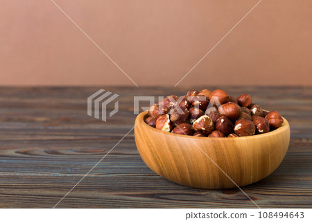 Wooden bowl full of hazelnuts on table background. Healthy eating concept. Super foods Wooden bowl full of hazelnuts on table background. Healthy eating concept. Super foods 108494643