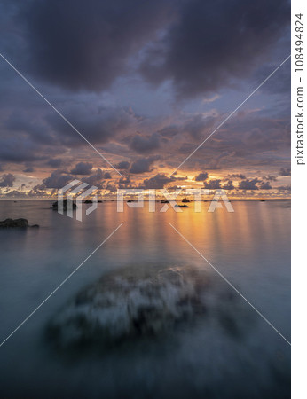 Beautiful scenery. sea sunset on the sea. Stones in the sea, a large stone is visible through the water column. Dramatic clouds and dark sky. Sunset in Phuket, Khaolak, Thailand. Beautiful scenery. sea sunset on the sea. Stones in the sea, a large stone is visible through the water column. Dramatic clouds and dark sky. Sunset in Phuket, Khaolak, Thailand. 108494824