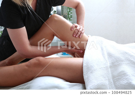 The specialist massages the legs. Body massage in a beauty salon. Muscle relaxation and cellulite elimination. The specialist massages the legs. Body massage in a beauty salon. Muscle relaxation and cellulite elimination. 108494825