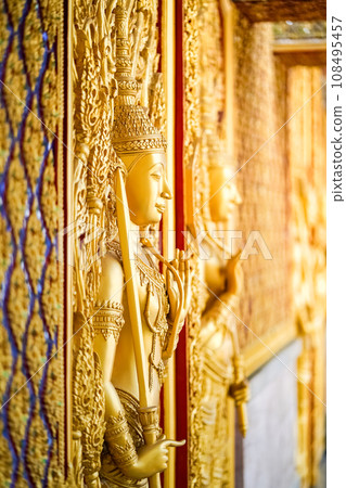 Gold door angel sculpture is a high relief art and is made of resin at the Golden Castle, Tha Sung Temple, Uthai Thani Gold door angel sculpture is a high relief art and is made of resin at the Golden Castle, Tha Sung Temple, Uthai Thani 108495457