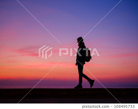 Woman tourist against colorful sunset sky. Travel, tourism concept. Active lifestyle. 108495733