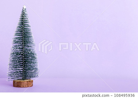 One small Christmas tree on colored background. new year decoration with copy space One small Christmas tree on colored background. new year decoration with copy space 108495936