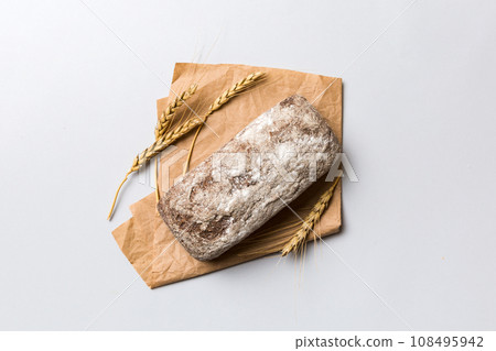 Fresh rye bread on napkin on rustic background, fresh bread top view Fresh rye bread on napkin on rustic background, fresh bread top view 108495942