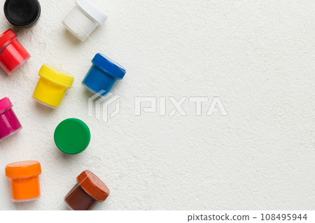 jars with gouache of different colors on Colored background. hobby painting. Top view with empty space. workplace for creativity. home teaching concept drawing jars with gouache of different colors on Colored background. hobby painting. Top view with empty space. workplace for creativity. home teaching concept drawing 108495944