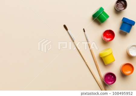 art palette with paint and brushes, close up. Top view with empty space. workplace for creativity. home teaching concept drawing art palette with paint and brushes, close up. Top view with empty space. workplace for creativity. home teaching concept drawing 108495952