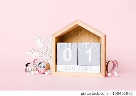 1 january. Christmas composition on colored background with a wooden calendar, with a gift box, toys, bauble copy space 1 january. Christmas composition on colored background with a wooden calendar, with a gift box, toys, bauble copy space 108495973