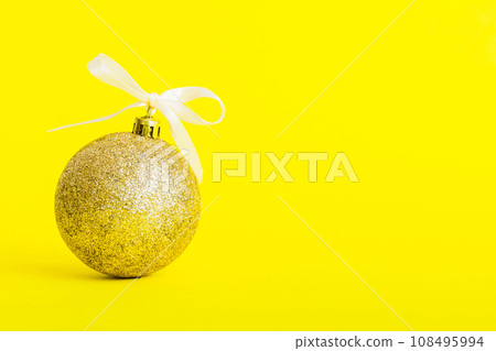 Christmas ball on colored background. decoration bauble with ribbon bow with copy space Christmas ball on colored background. decoration bauble with ribbon bow with copy space 108495994