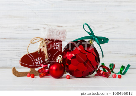 Christmas ball with skates on colored background. decoration bauble with ribbon bow with copy space Christmas ball with skates on colored background. decoration bauble with ribbon bow with copy space 108496012