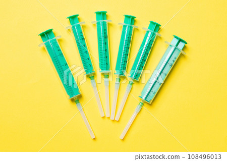 Top view of different syringes for injection on colorful background. Medical equipment concept with copy space 108496013