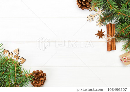 Christmas background with fir tree and gift box on wooden table. Top view with copy space for your design Christmas background with fir tree and gift box on wooden table. Top view with copy space for your design 108496207