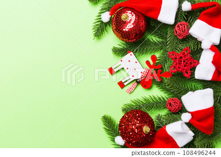 Christmas composition made of fir tree, balls and different decorations on colorful background. Top view of New Year Advent concept with empty space for your design 108496244