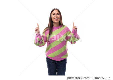 surprised pleasant young european brunette woman dressed in a striped pink-green pullover gesturing 108497006