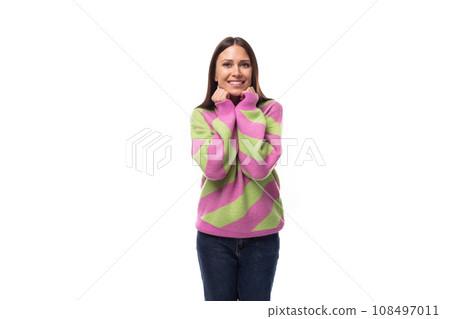 pretty young european brunette woman dressed in a striped pink pullover on a white background with pretty young european brunette woman dressed in a striped pink pullover on a white background with 108497011