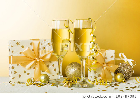 Champagne glasses and christmas decor on colored holiday background. Flat lay New Year decorations 108497095