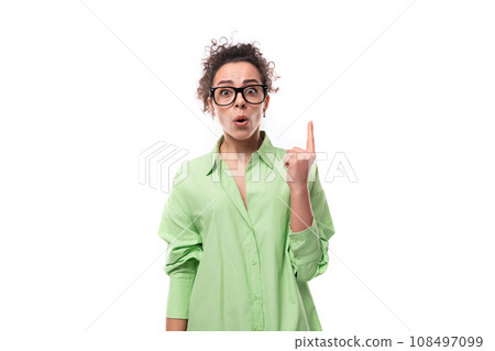 young stylish caucasian secretary woman with black curly hair in glasses and light green shirt on a young stylish caucasian secretary woman with black curly hair in glasses and light green shirt on a 108497099